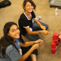 Students sit down to play a game activity with red cups