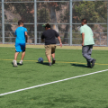 students play soccer as a group and with advisors